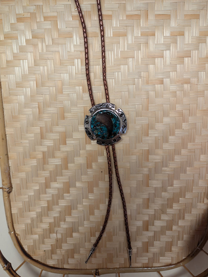 Silver BadAssBabe bolo tie featuring a detailed western-style metal clasp and black cord for a bold, stylish look.
