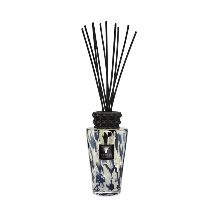 A Pearls Black Diffuser with a floral patterned glass bottle and a decorative cap, equipped with black reeds for fragrance diffusion.