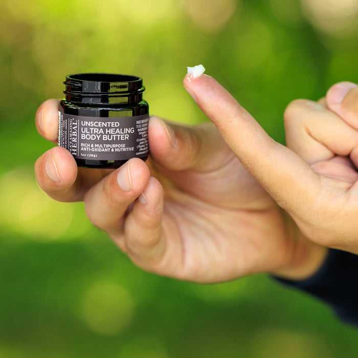 Photo of a hand holding body butter for eczema scooping some out with a finger