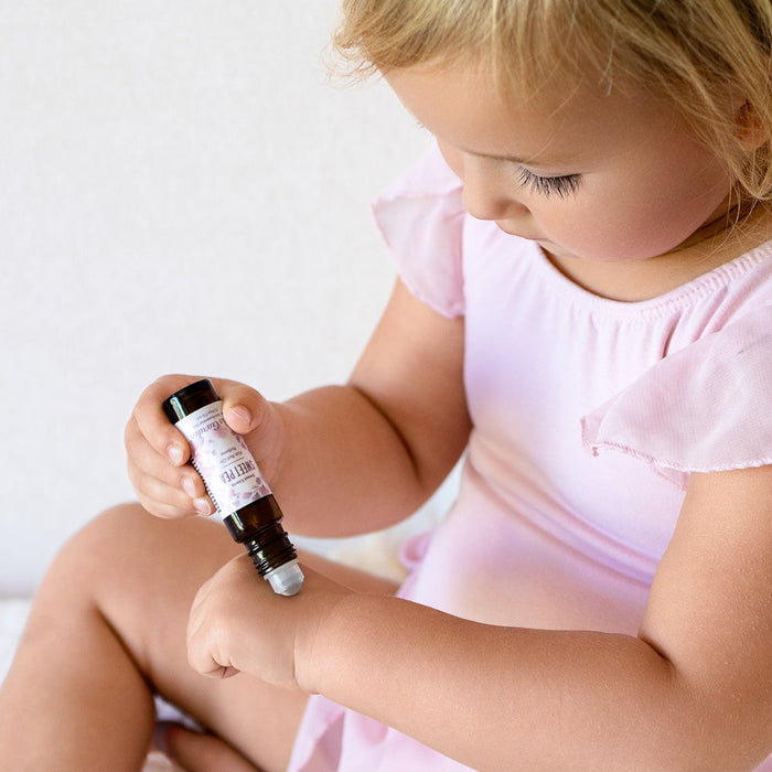 Child holding a small bottle with a white background