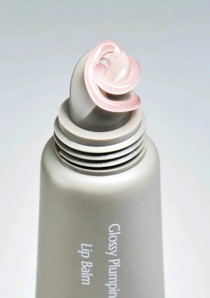 Lip balm with pink cap on a light gray background