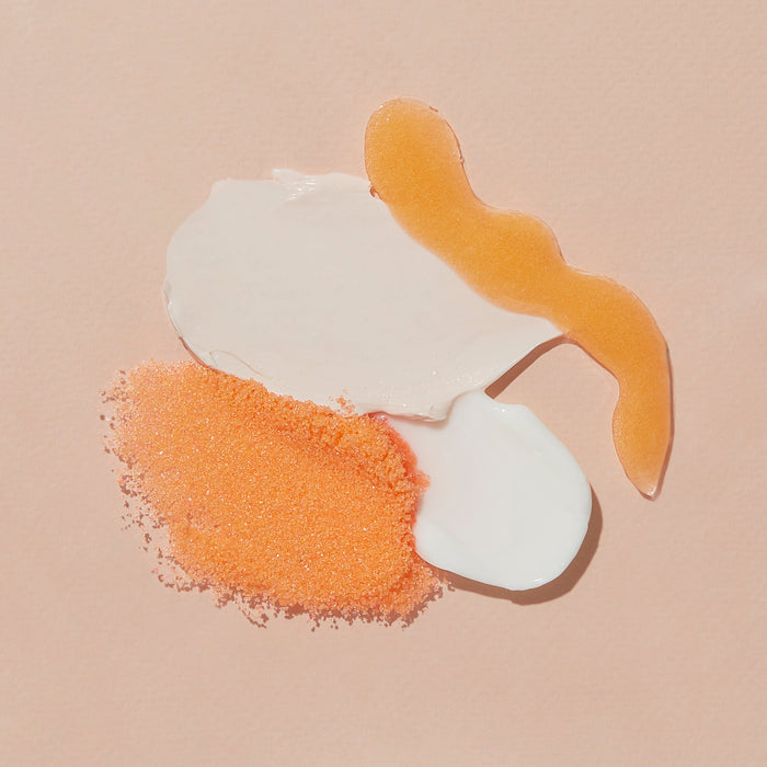 White and orange cosmetic product on a beige background